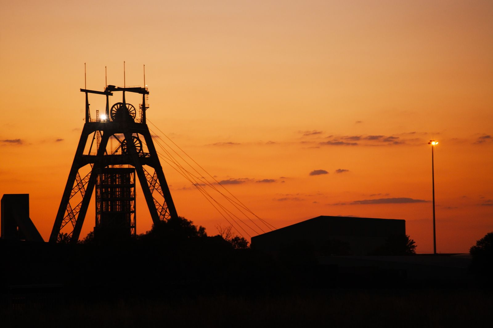 A mine head shaft silhouetted at sunset — the platinum operation at the centre of the dispute.